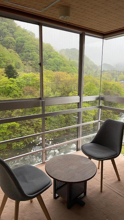 日光いろはの川が見える施設内部の椅子とテーブル